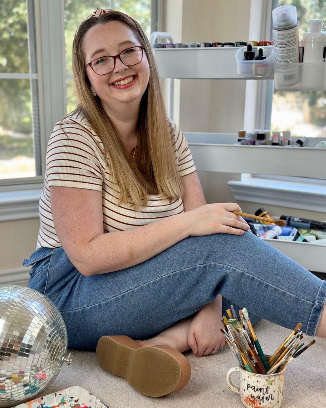 Jessie in her creative studio with paintbrushes
